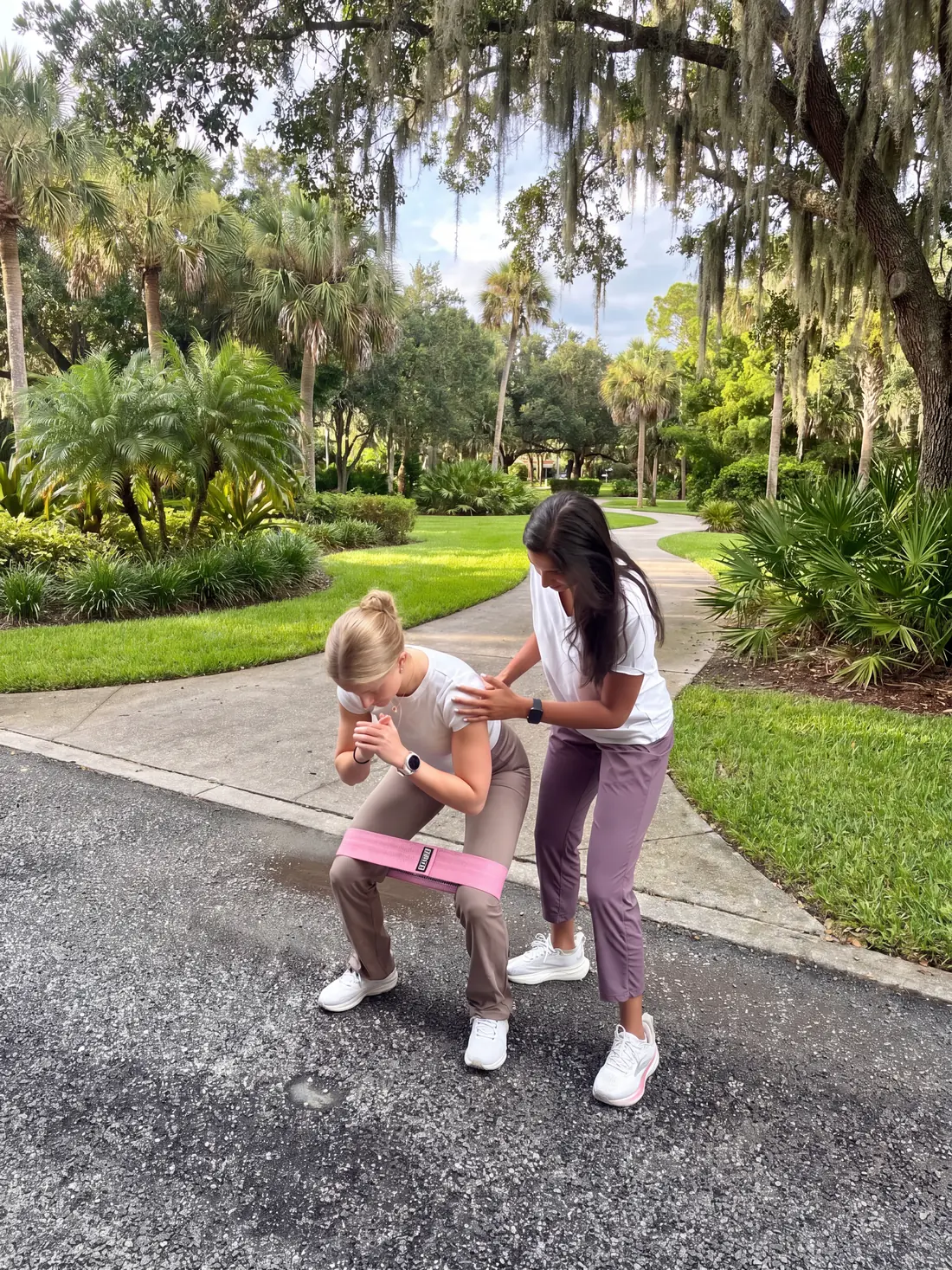 Alisha coaching a patient through a banded squat in a Tampa park